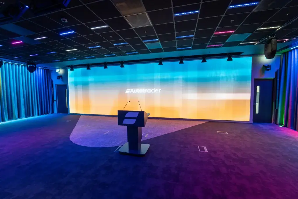 Stage area for presentations featuring a large LED screen, audio and lighting